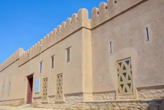 De buitenmuur van Al Hillah Fort met gekanteelde borstwering en geometrisch versierde vensters