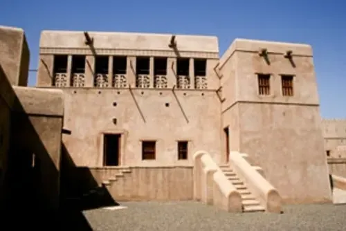 Het versierde bovenhuis van Al Hillah Fort met een opengewerkte balustrade, sierlijke vensters en een buitentrap