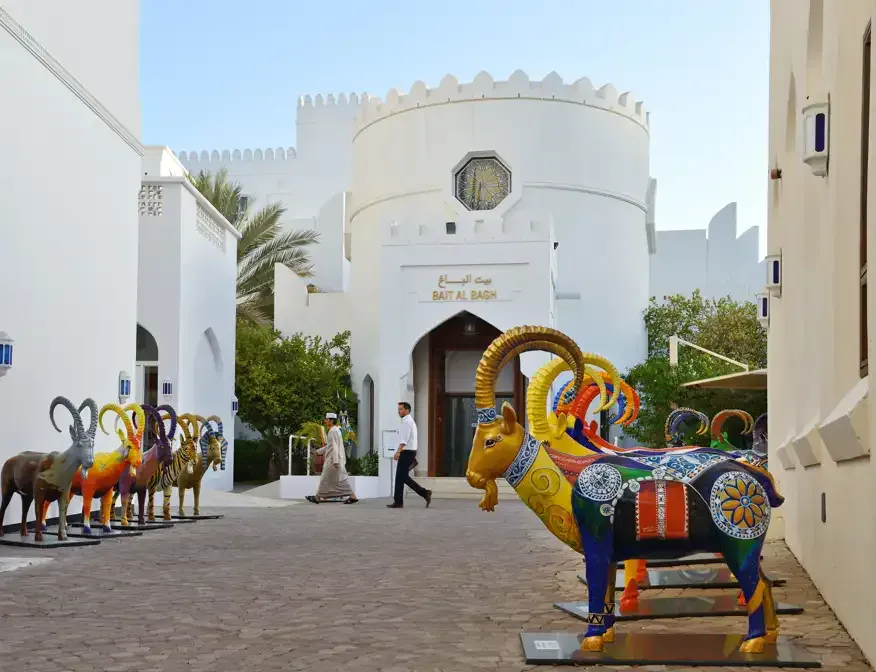 Een rij kleurrijk beschilderde geitensculpturen voor het Bait Al Bagh van het Bait Al Zubair Museum