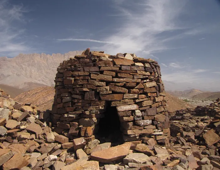 Een goed bewaarde stenen beehive-tombe uit de bronstijd bij Al-Ayn, met de kartelige Jebel Misht op de achtergrond