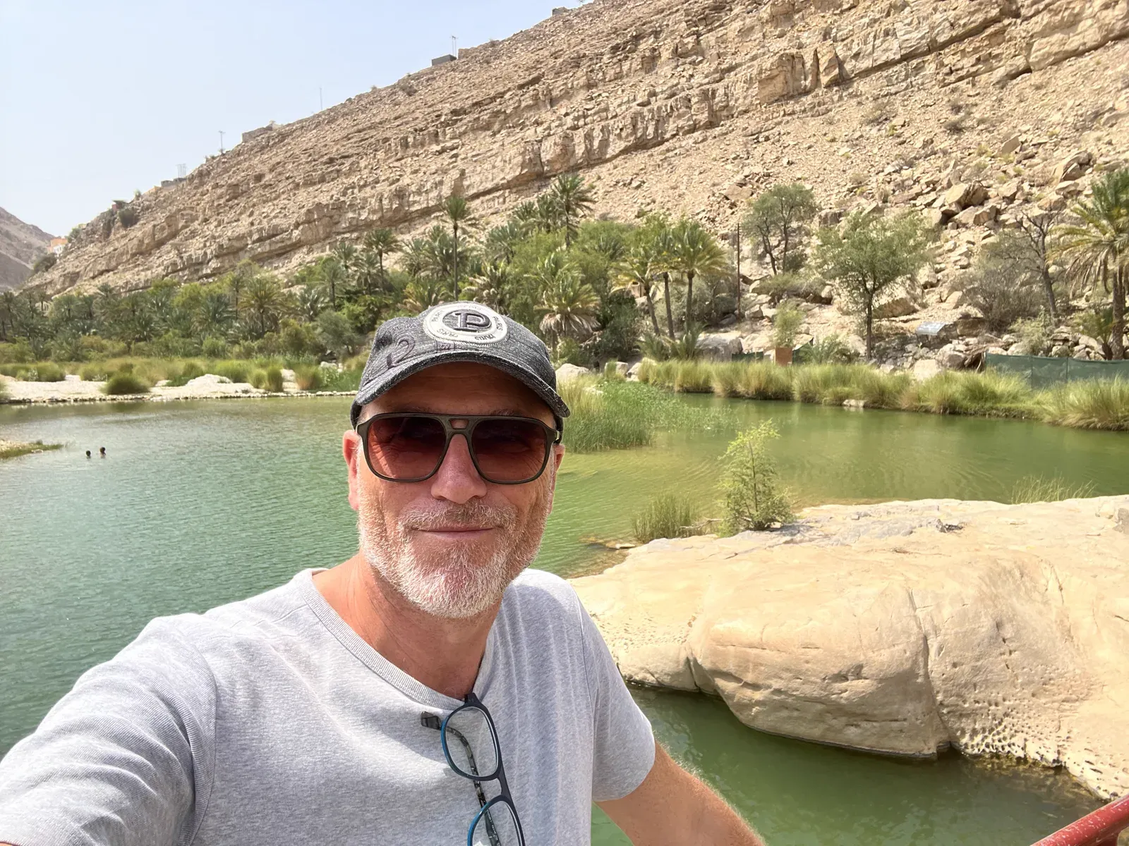 Frank bij de groene poelen van een wadi tussen de rotswanden in Oman