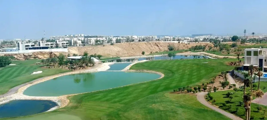 Panorama over de Muscat Hills-golfbaan met waterpartijen, gezien vanaf het Tivoli-hotel