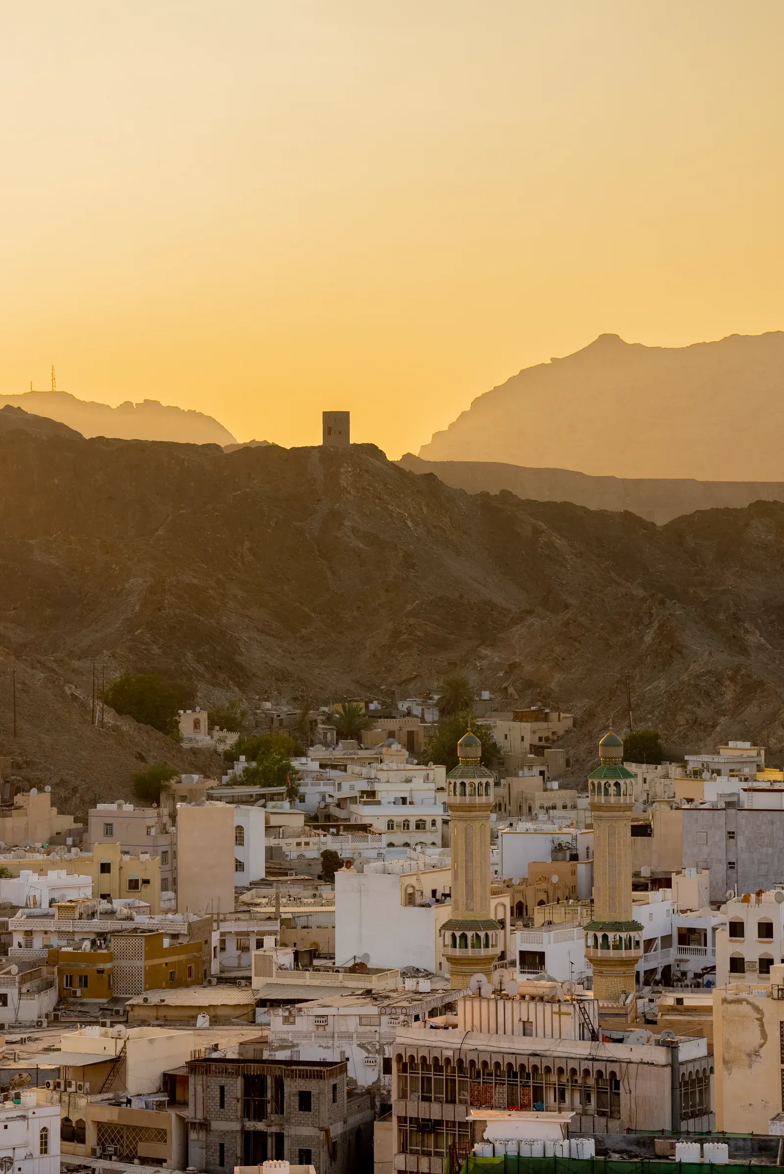 De oude stad van Muscat tussen de Hajar-bergen met wachttoren