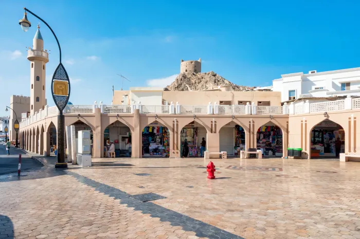 Het overdekte plein van de Mutrah Souq aan de Corniche van Muscat, met het Mutrah-fort op de heuvel erachter
