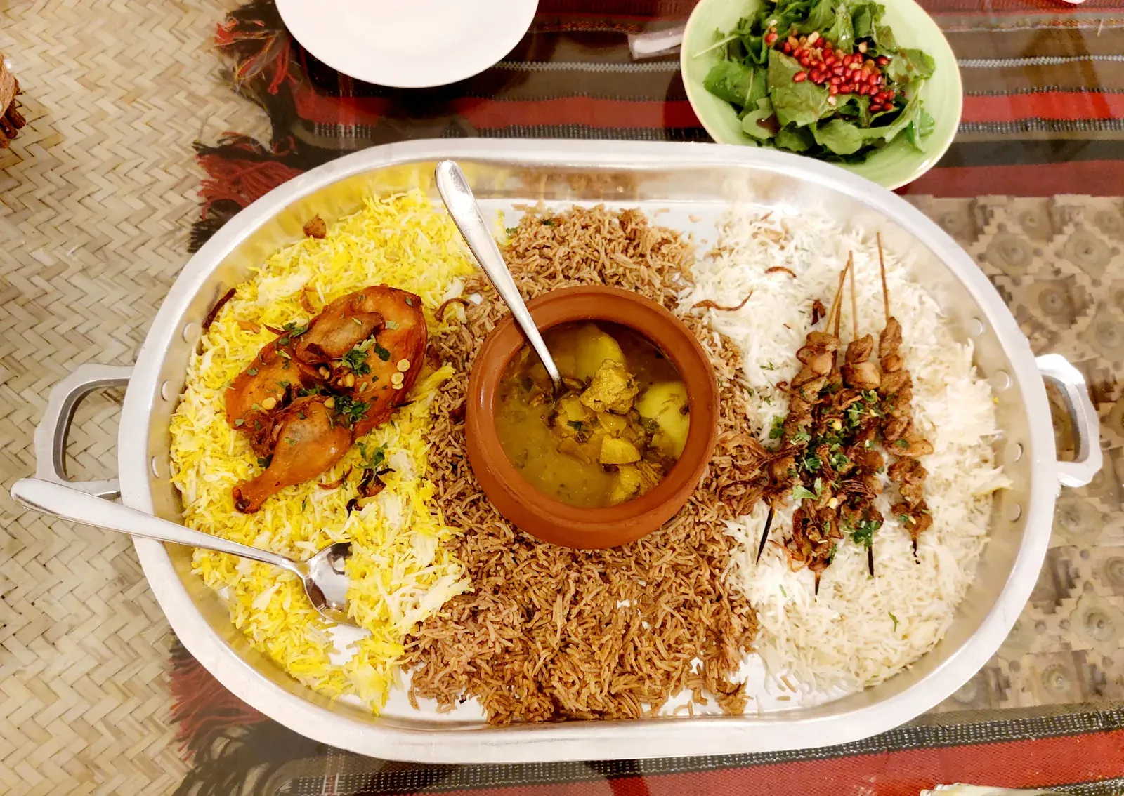 Een gedekte schaal met traditioneel Omaans gerecht in restaurant Ramssa: geurige rijst, mals vlees, curry en spiesjes