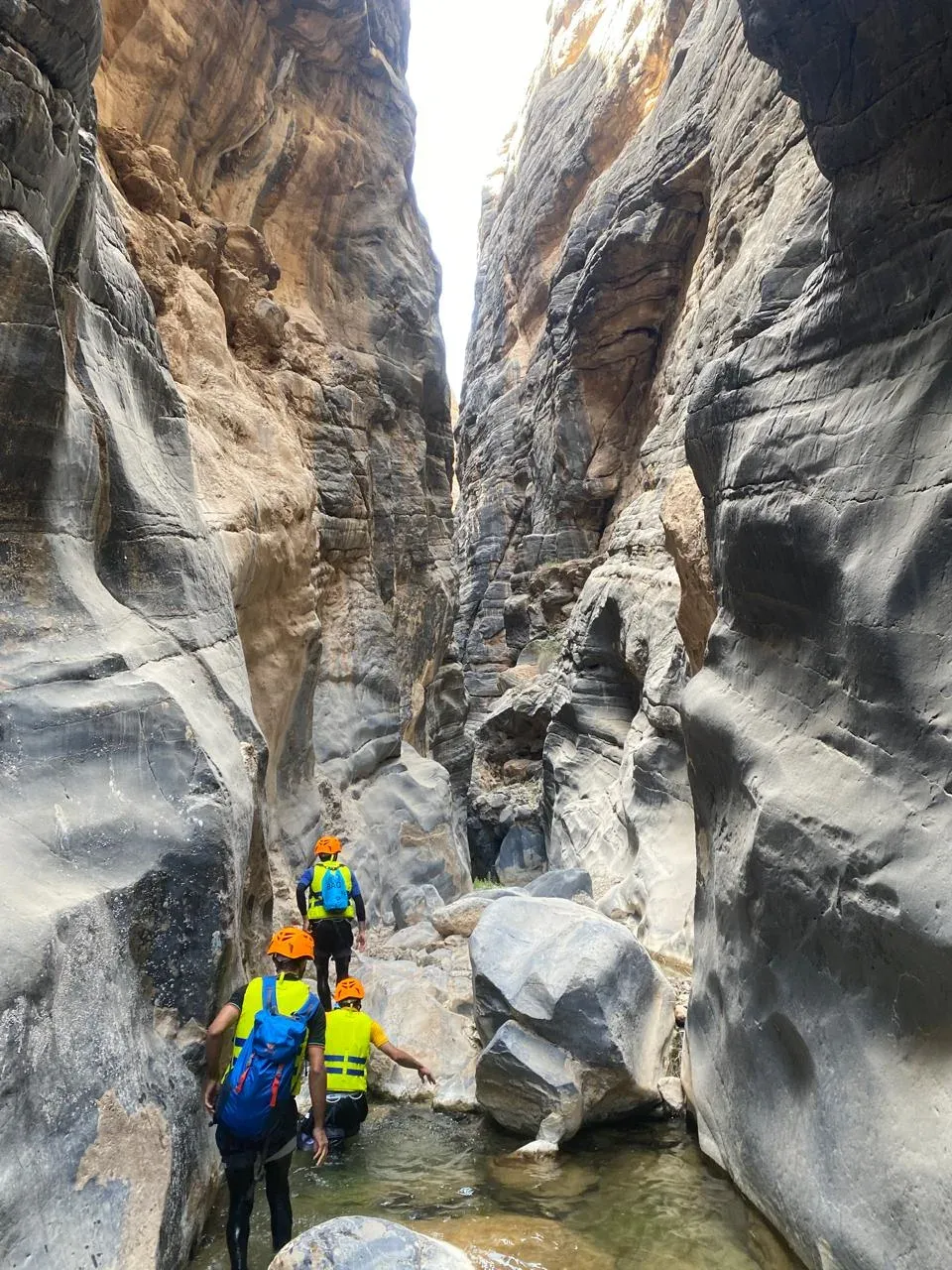 De hoge, gladgeslepen wanden van de nauwe kloof van Snake Canyon met wandelaars als schaal